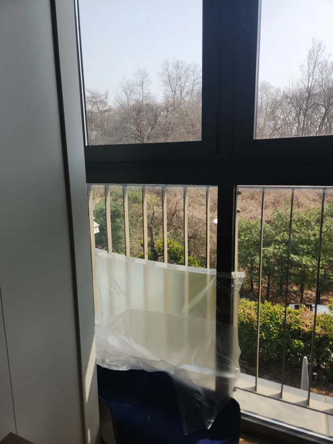 겨울 나무가 보이는 큰 창과 베란다 난간