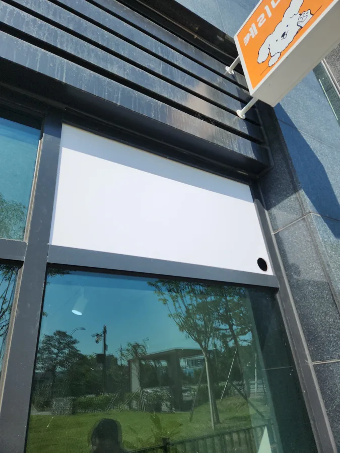 상가 건물 외벽 유리와 하단에 뚫린 작은 원형 홀